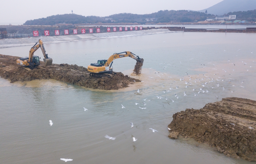 2019年12月23日，鳥群從陸島轉(zhuǎn)換圍堰回水施工現(xiàn)場飛過。